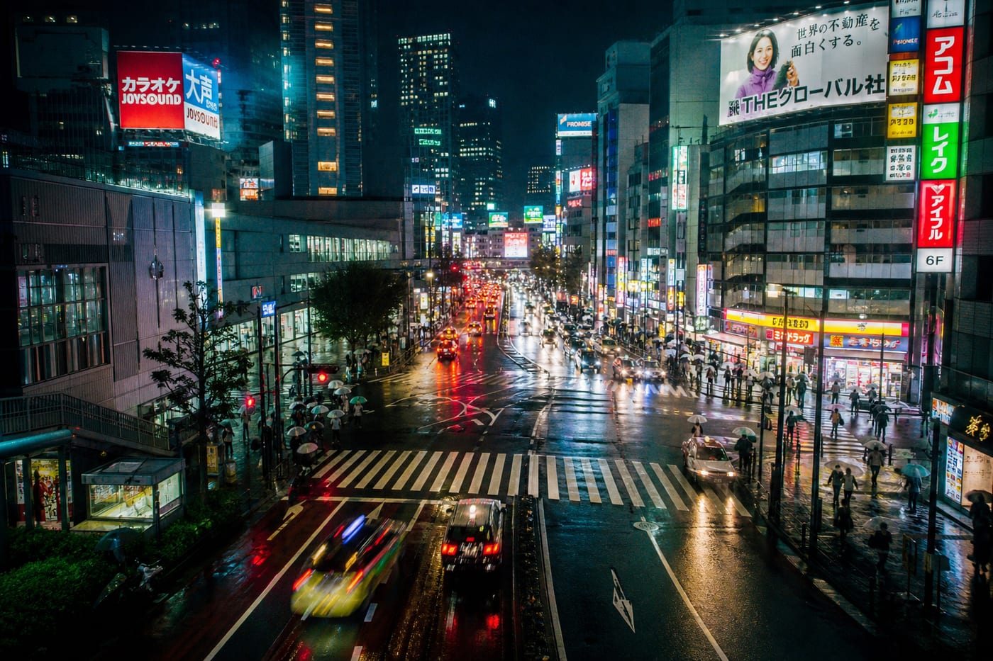 Calle de Tokio de noche con reflejos de neón en el asfalto mojado